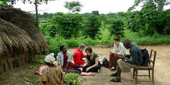 Students work with community members in Uganda to collect data on mobile devices